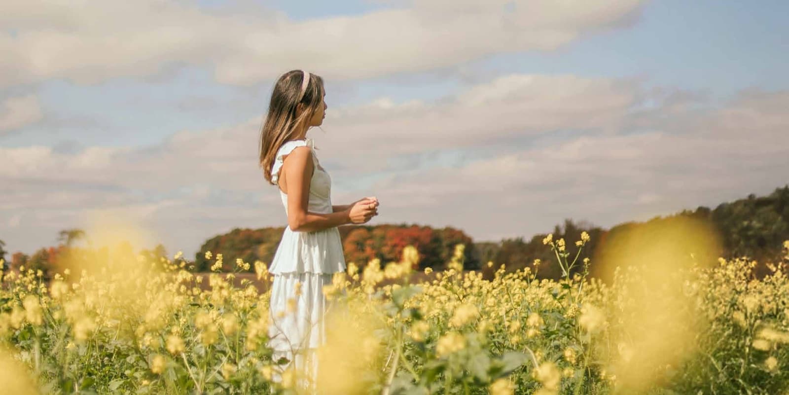 Woman walking through a sunlit canola field in the countryside near Upper Markham